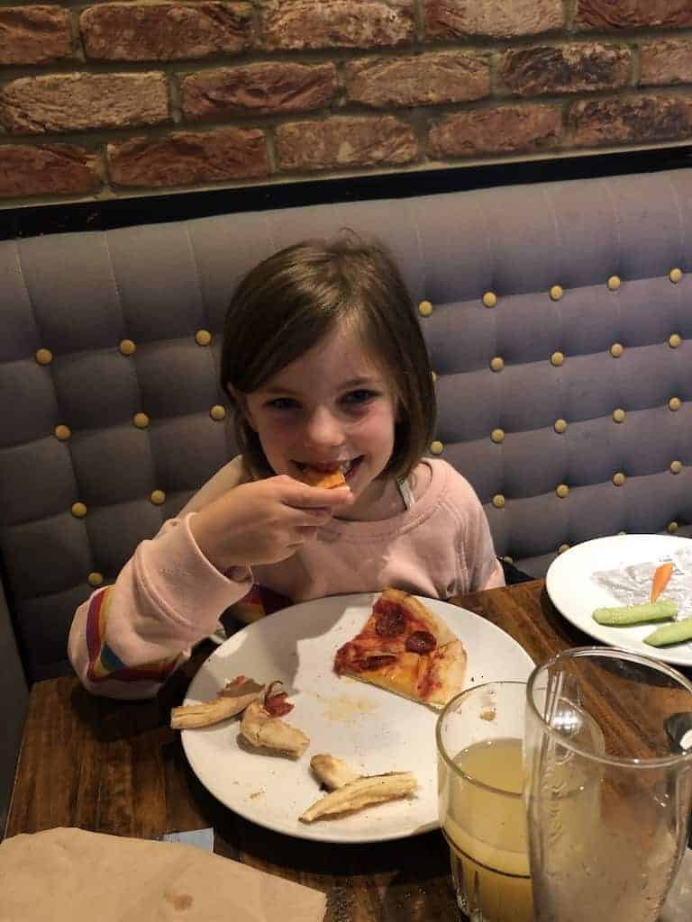 Child eating allergy friendly pizza at Zizzi restaurant