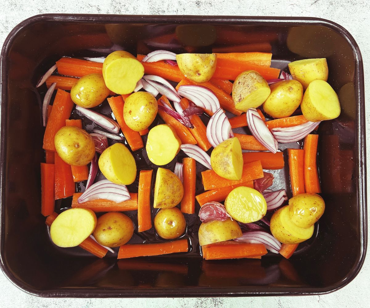 carrots potatoes and red onion in a roasting tin