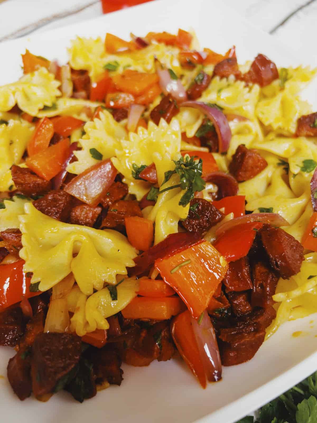 close up of chorizo red peppers, onion in a pasta salad