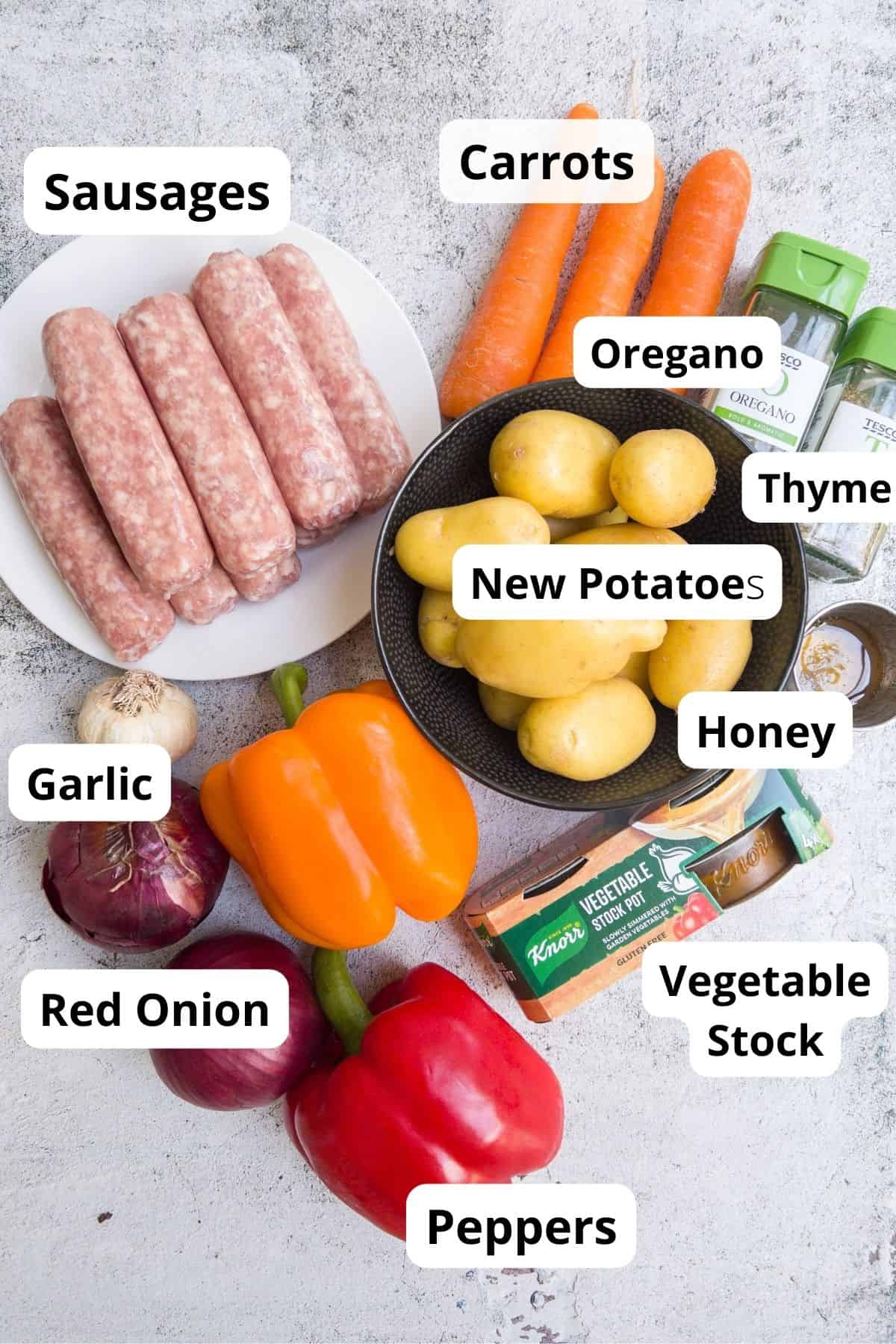 Ingredients for a sausage traybake including potatoes and peppers