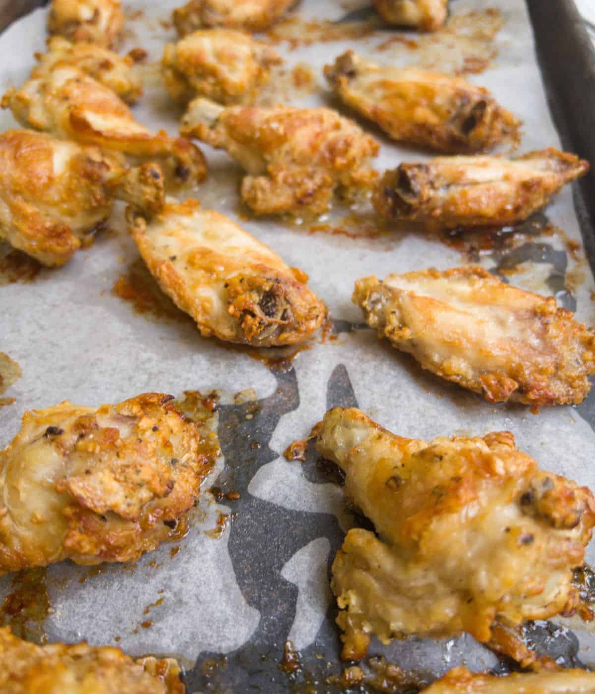 close up of cooked chicken wings on a baking tray