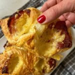Someone holding a bacon and cheese turnover.