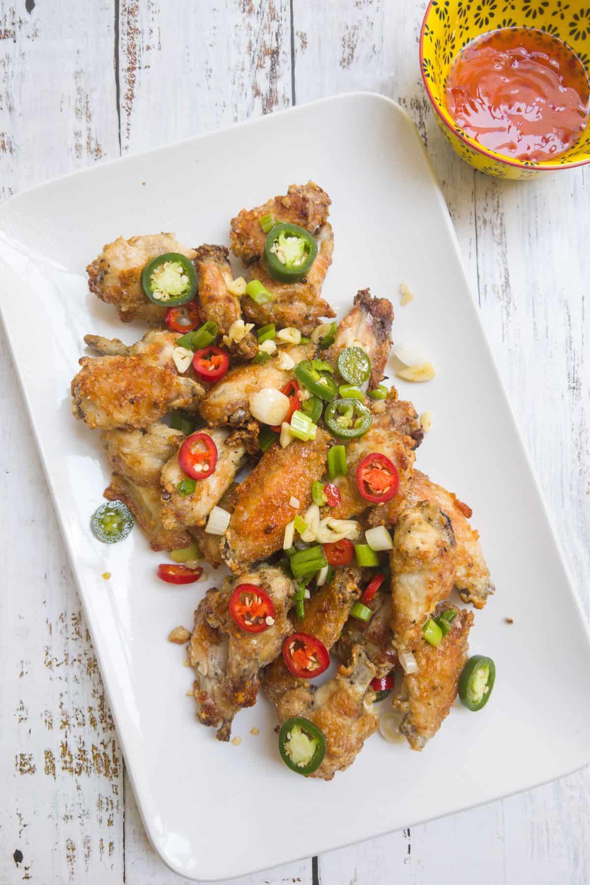 chinese style salt and pepper chicken wings on a white serving dish