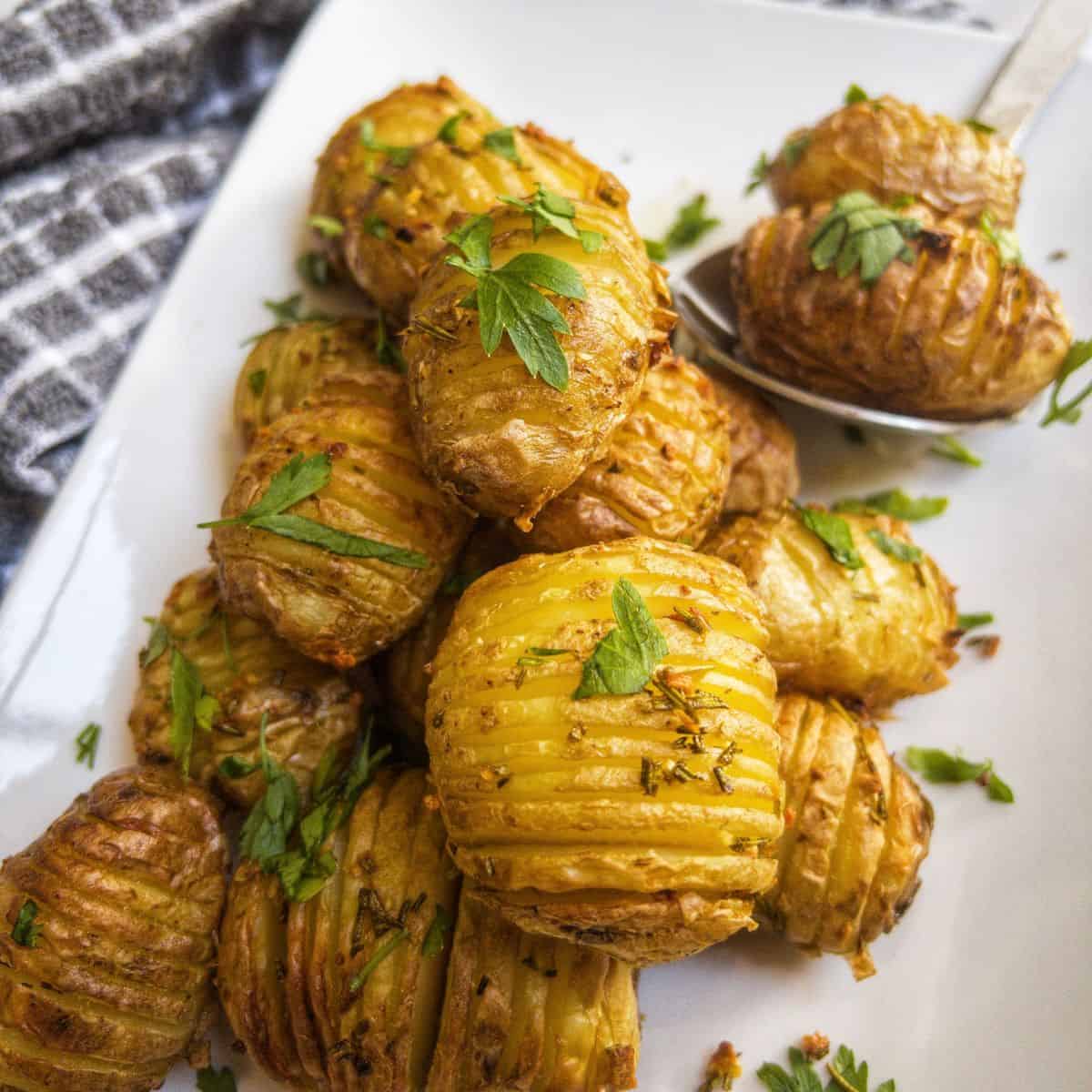 close up shot of mini hasselback potatoes garnished with parsley.