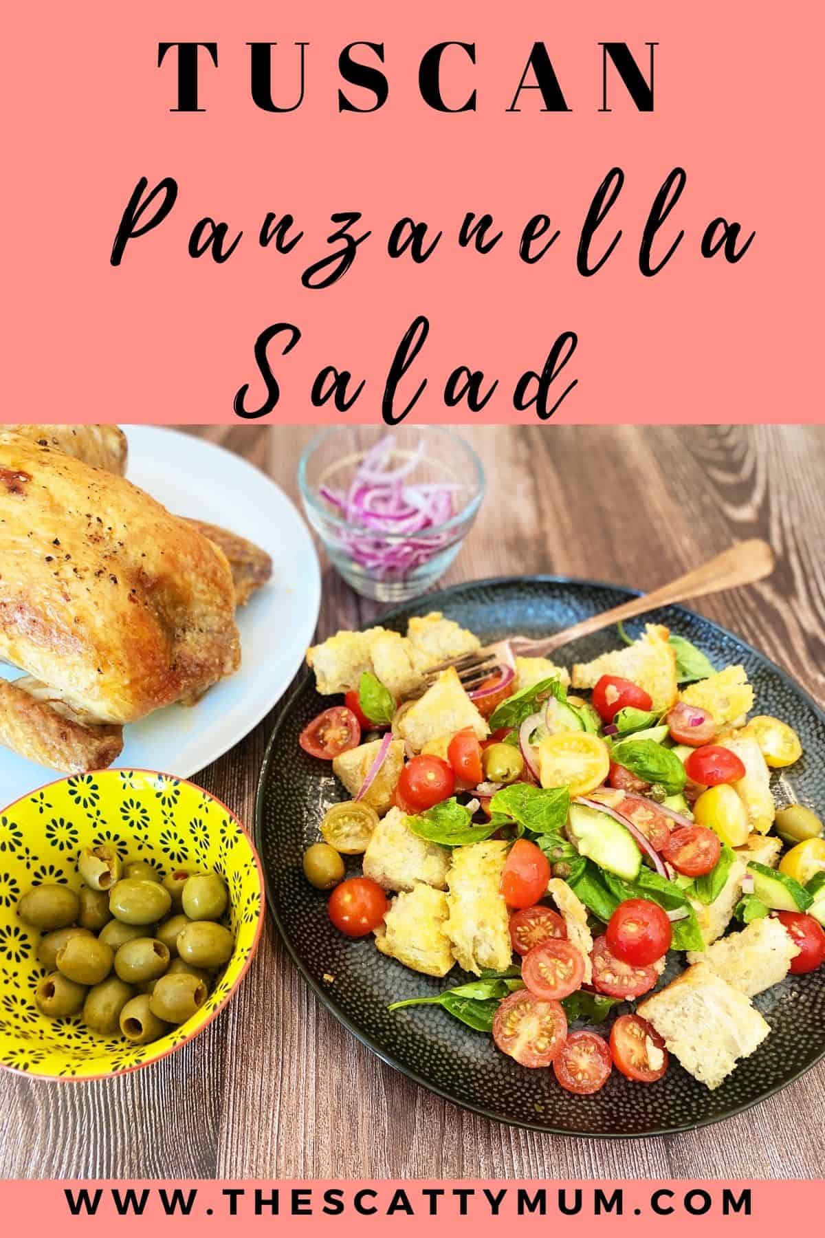 pinterest image of Panzanella Salad on a black plate with a roast chicken and olives