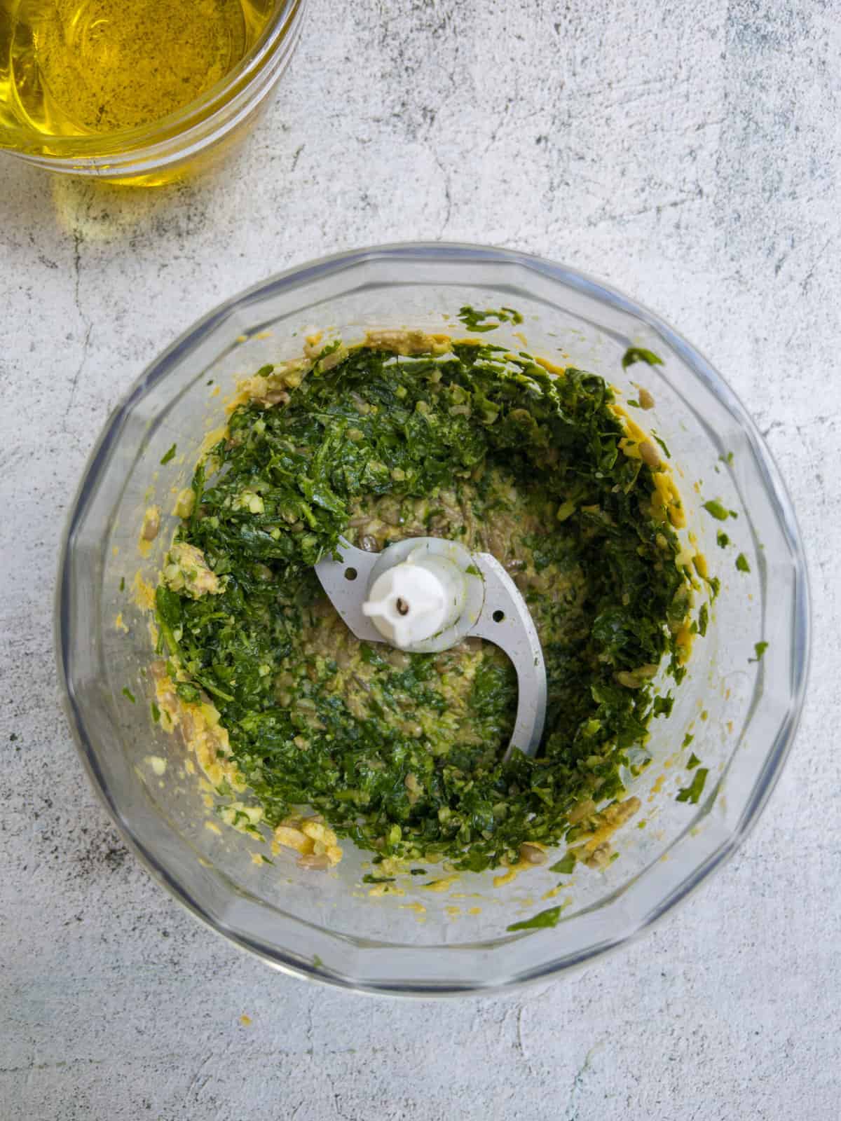 ingredients for dairy and nut free pesto in a food processor.