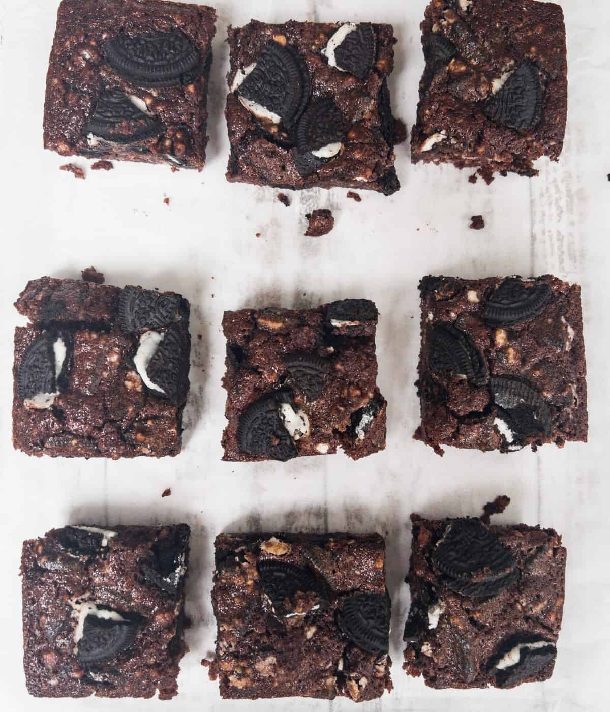 vegan oreo chocolate brownies sliced into squares on a white background