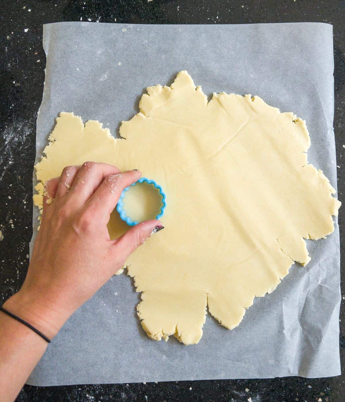 cutting out shortbread cookies with a cutter.