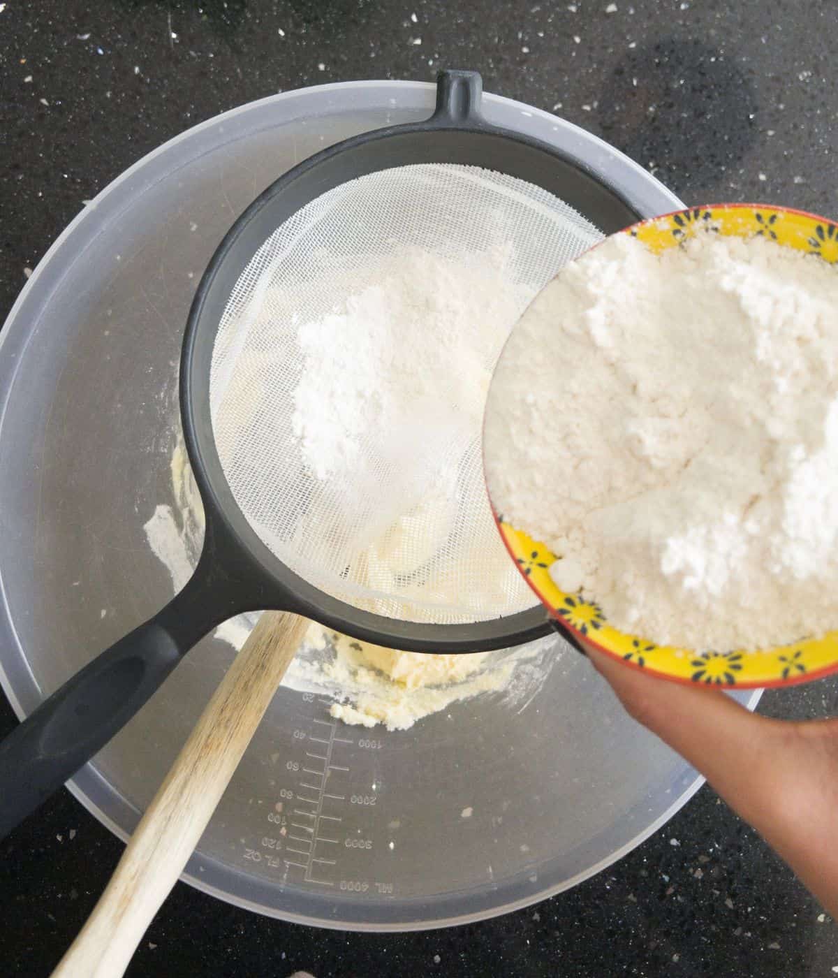 flour being sifted into a mixing bowl.