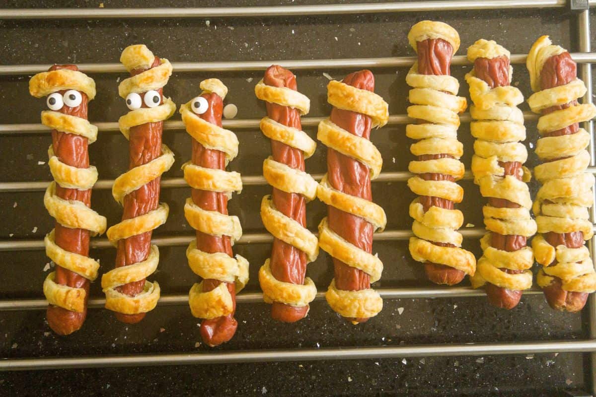 sausage mummies |(puff pastry wrapped frankfurters with edible eyes) cooling on a cool rack.