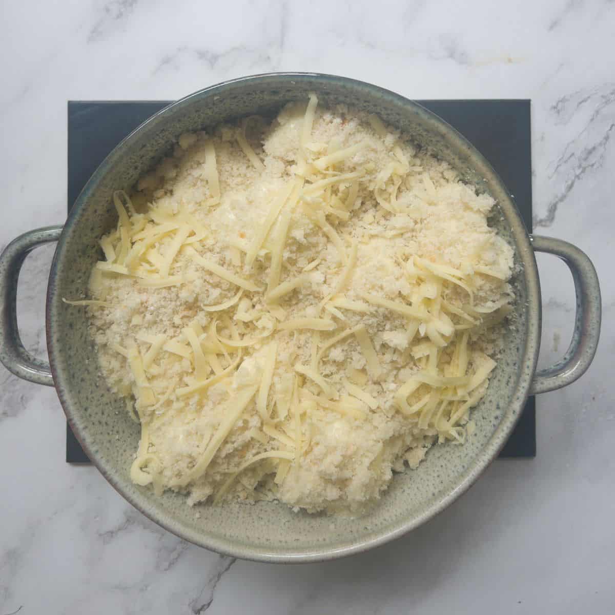cauliflower cheese in a casserole dish before it has been baked.