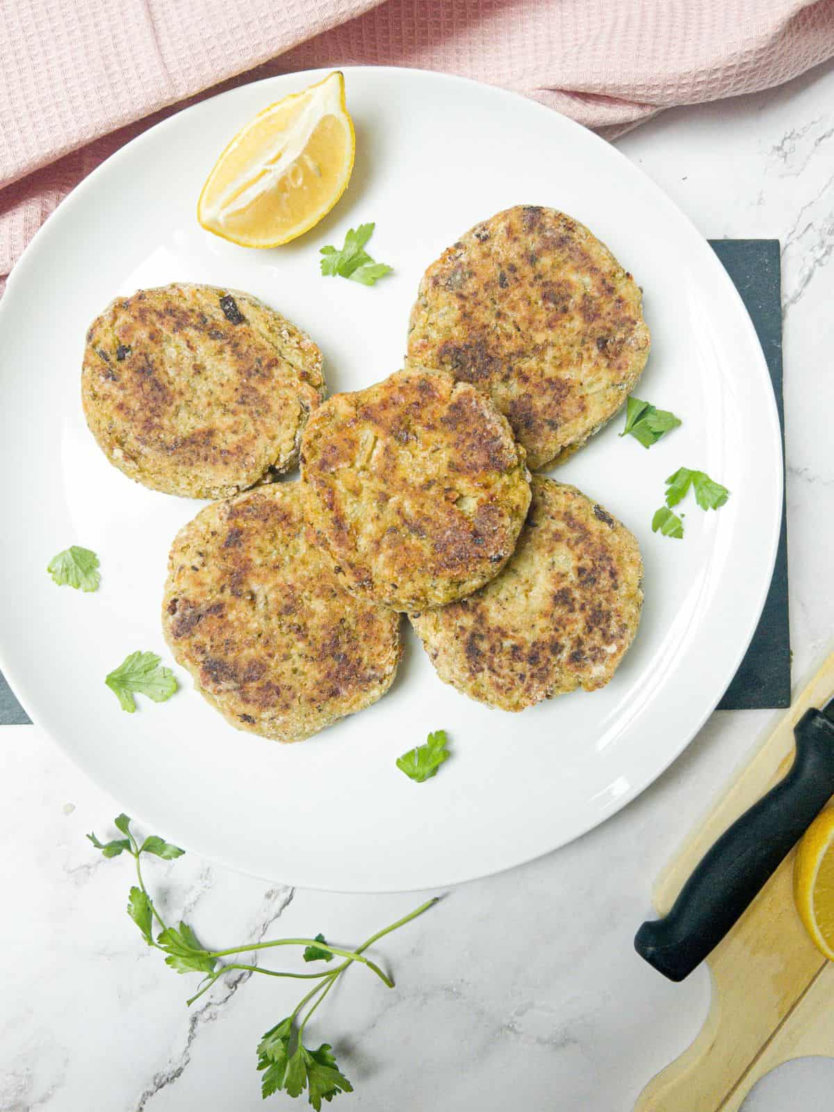 bubble and squeak patties on a plate garnished with lemon.