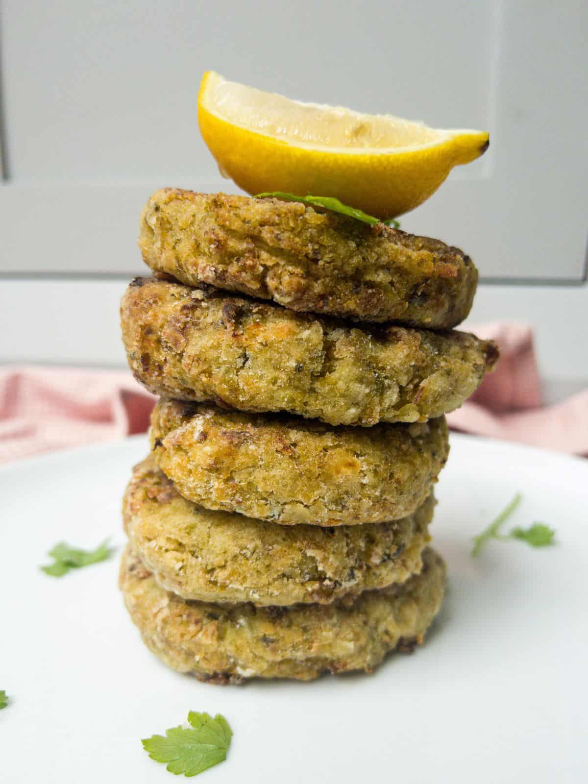 a tower of bubble and squeak patties with a slice of lemon on top.