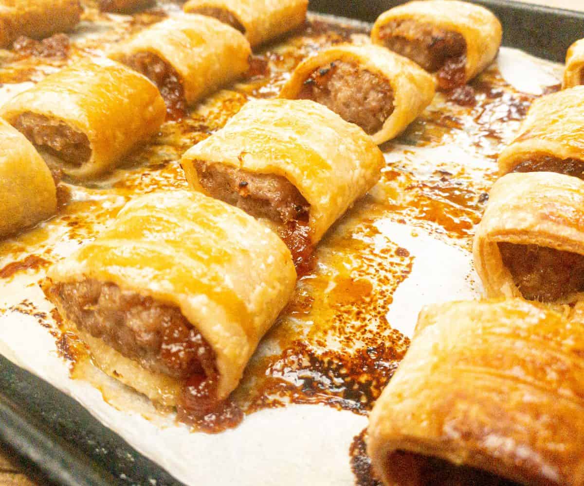 mini sausage rolls on a baking tray fresh from the oven.