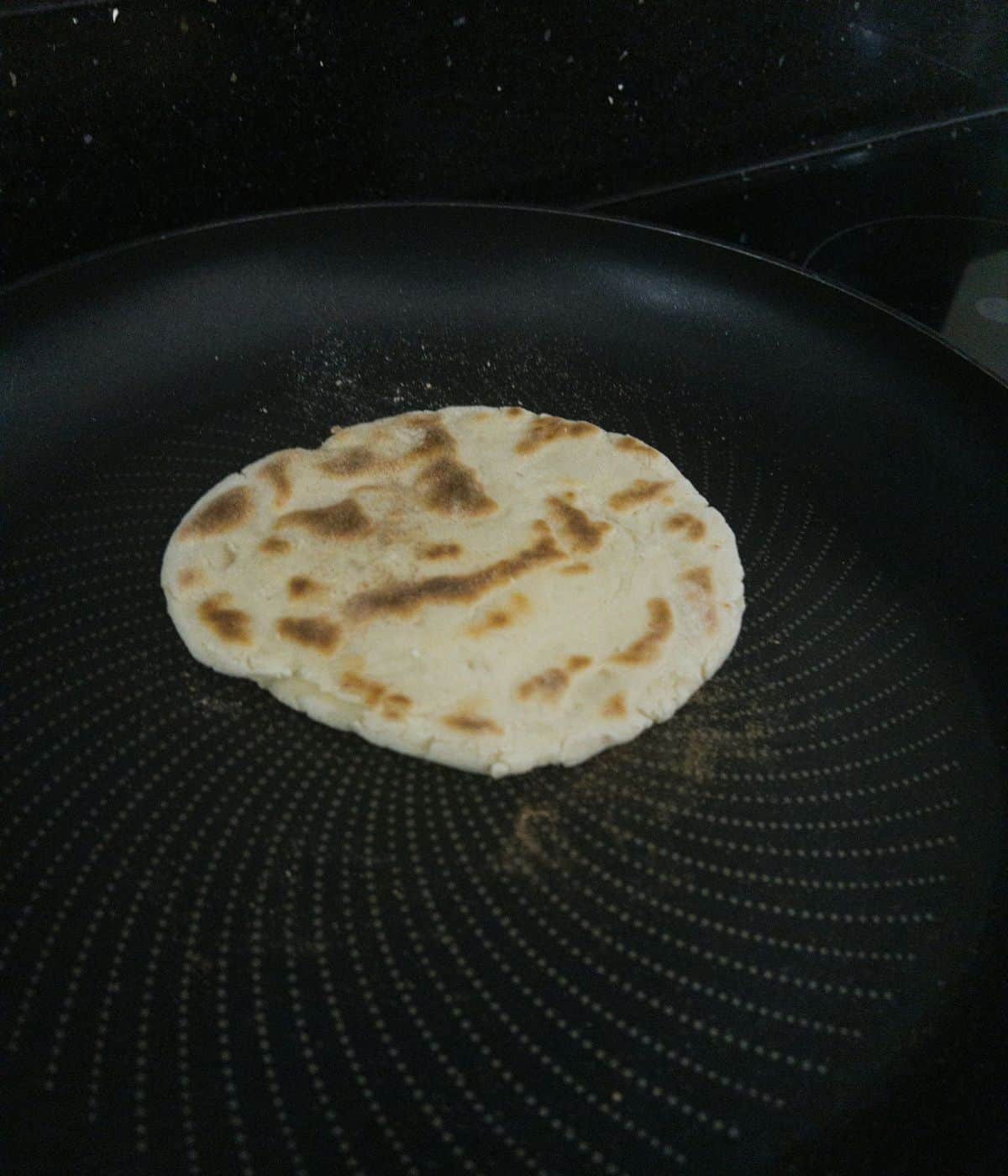naan bread dry frying in a frying pan.