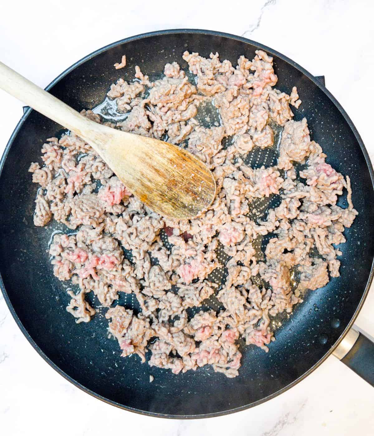 Lamb mince being fried off in a pan.