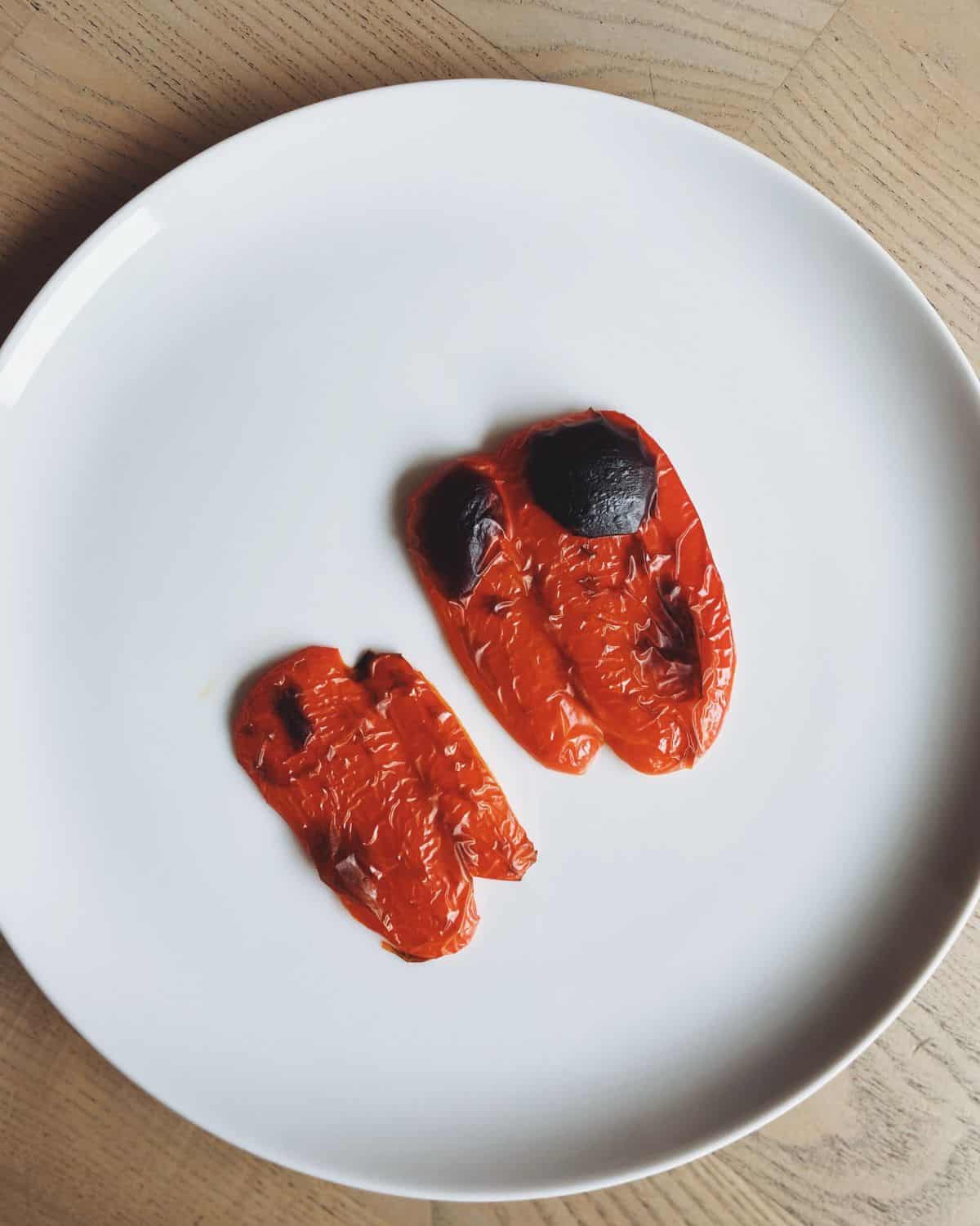 grilled red peppers on a white plate.