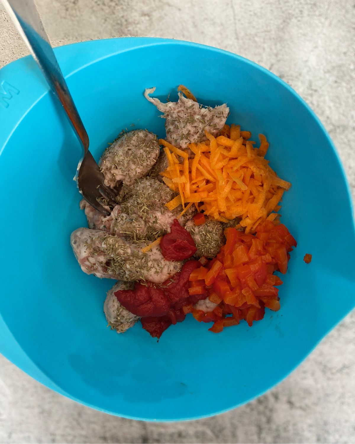 sausage meat carrot, red pepper and thyme in a bowl.