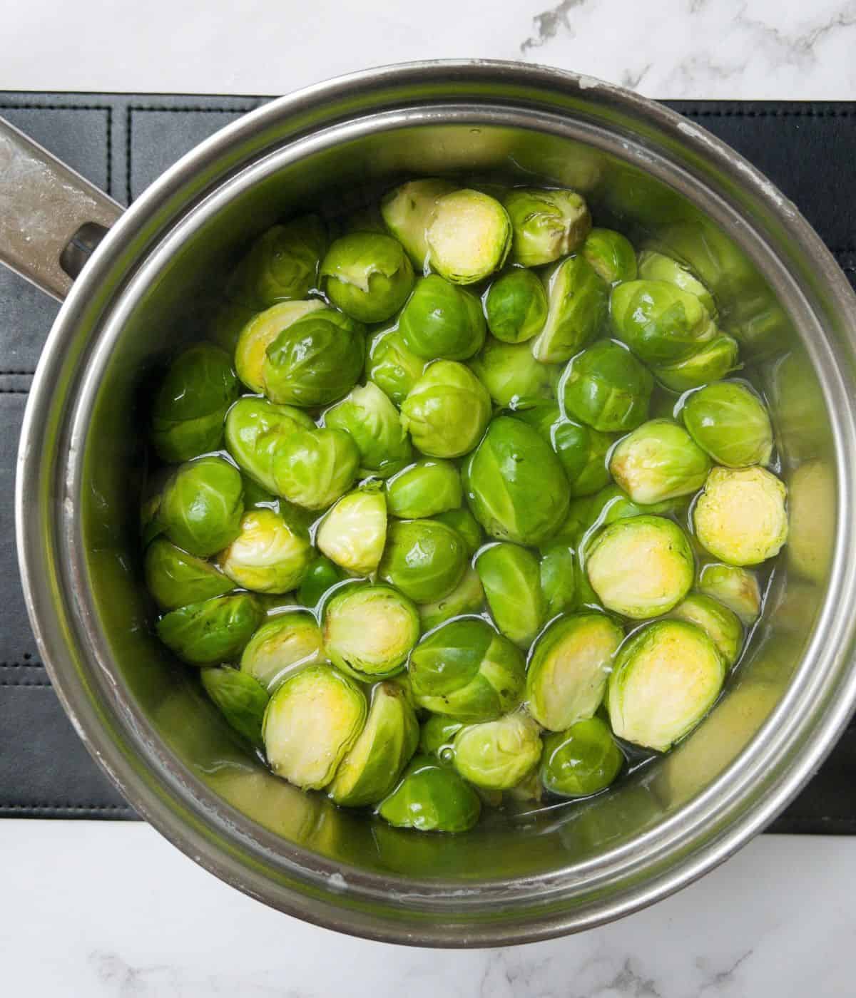 Brussel sprouts boiling in. a saucepan.