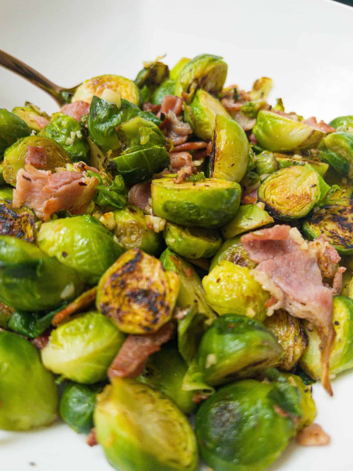 Close up shot of brussel sprouts with bacon & garlic.