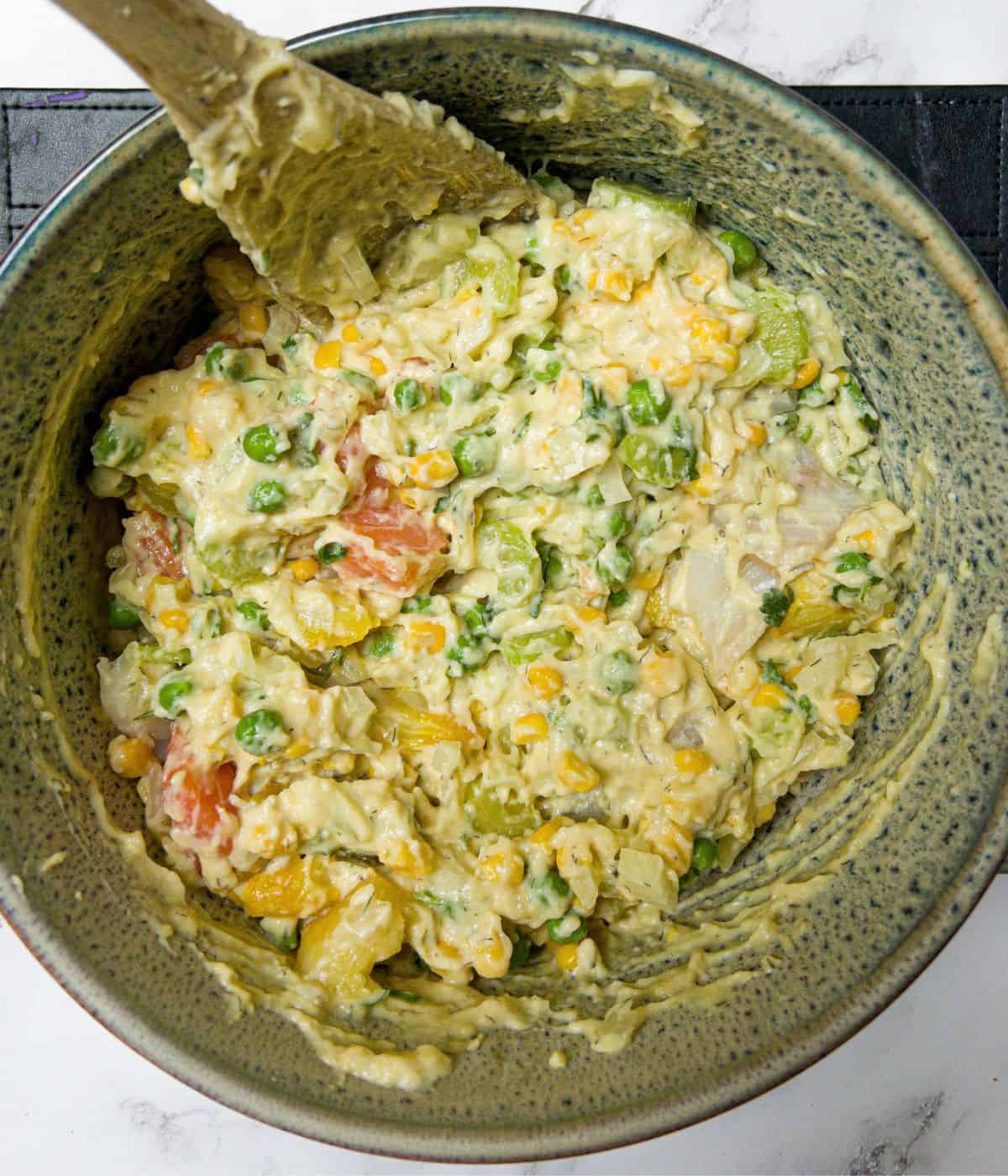 Fish pie contents being mixed in a casserole dish prior to baking.