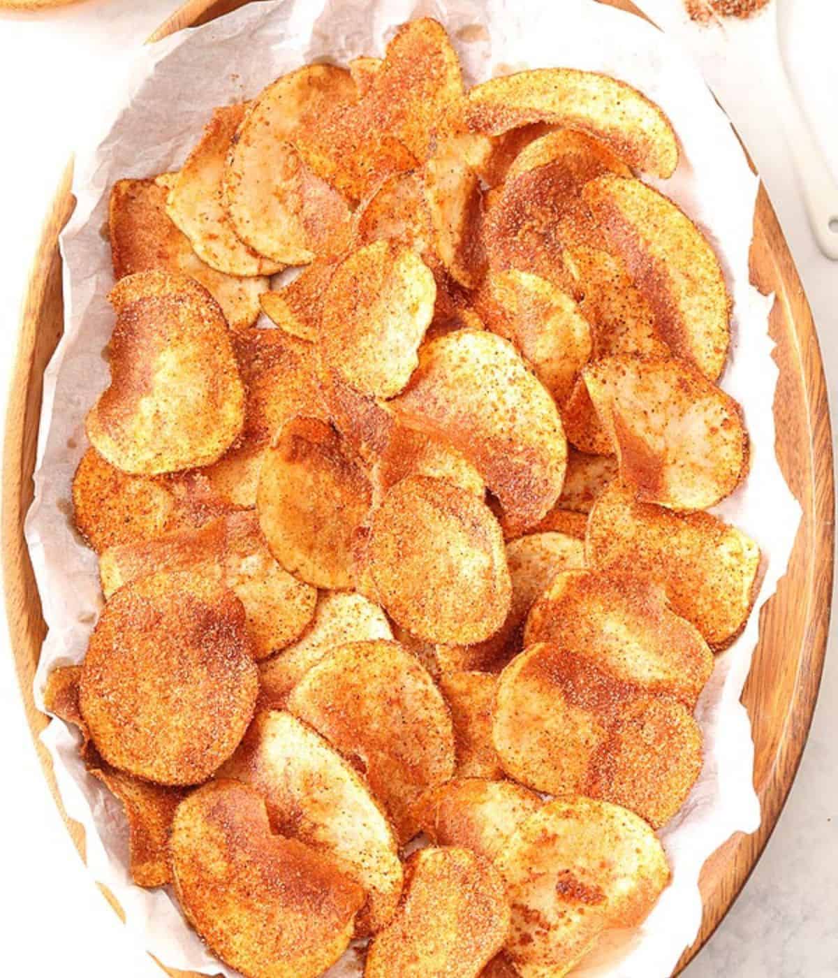 Crisps in a wooden bowl lined with some white kitchen towel.