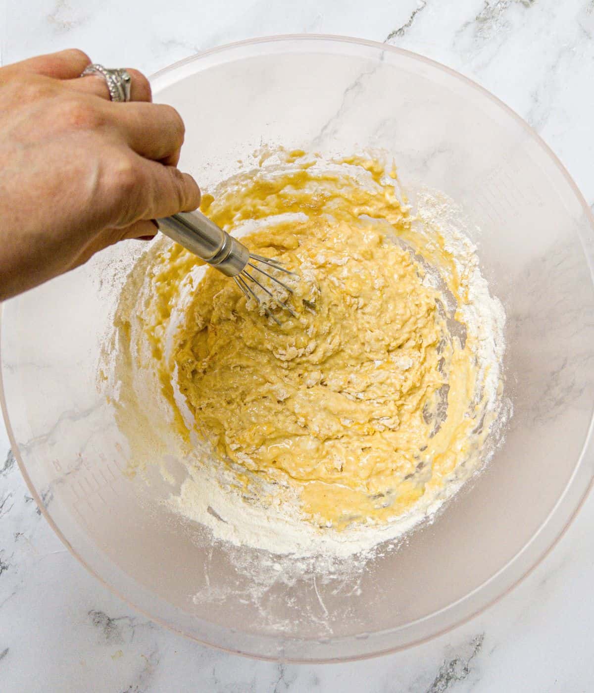Crepe batter being whisked in a bowl.