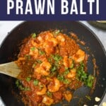 Prawn balti in a black frying pan with a wooden spoon in it.