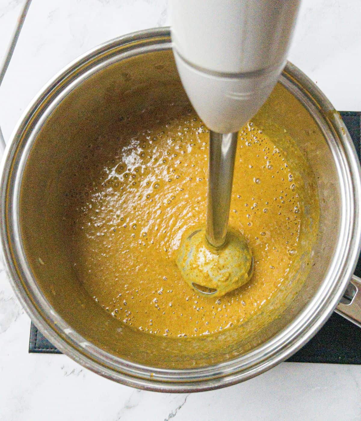 Katsu curry sauce being blended in a saucepan.