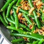 Green beans garnished with almonds and lemons.