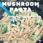 Creamy fusilli pasta with broccoli and mushroom being stirred in a frying pan.