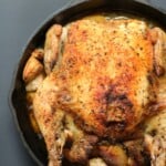 Whole roasted chicken in a pan.