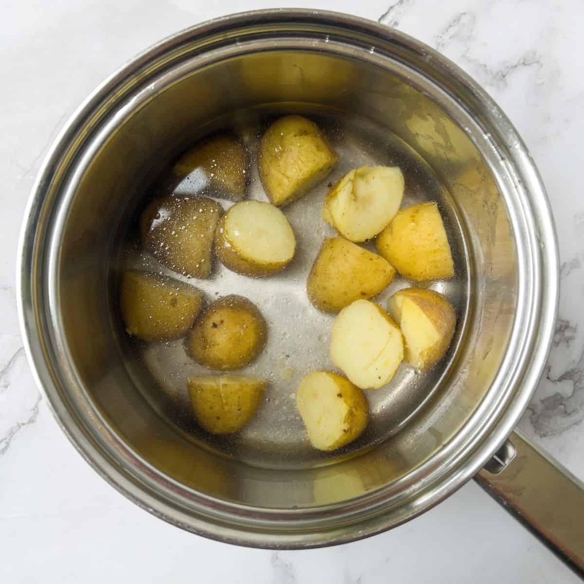 New potatoes boiling in water in a saucepan.