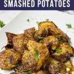 Smashed new potatoes on a white plate garnished with parsley.