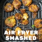 Cooked smashed potatoes in an air fryer basket.