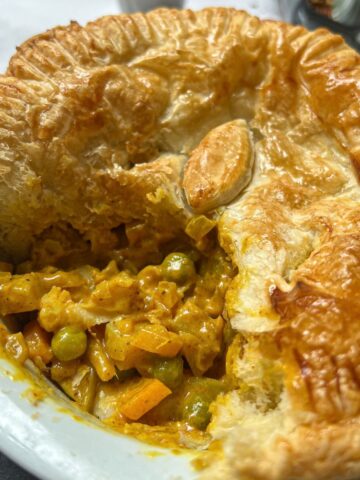 Curry pie with a slice cut out of it.