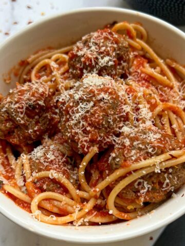 A bowl of spaghetti and meatballs.
