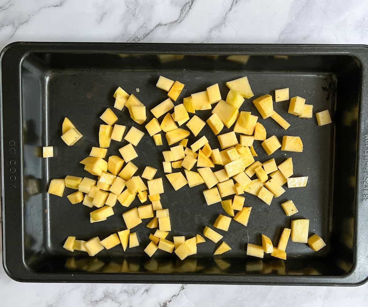 Cubes of swede on a rectangular baking tray.