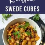 A bowl of roasted swede cubes garnished with fresh parsley.