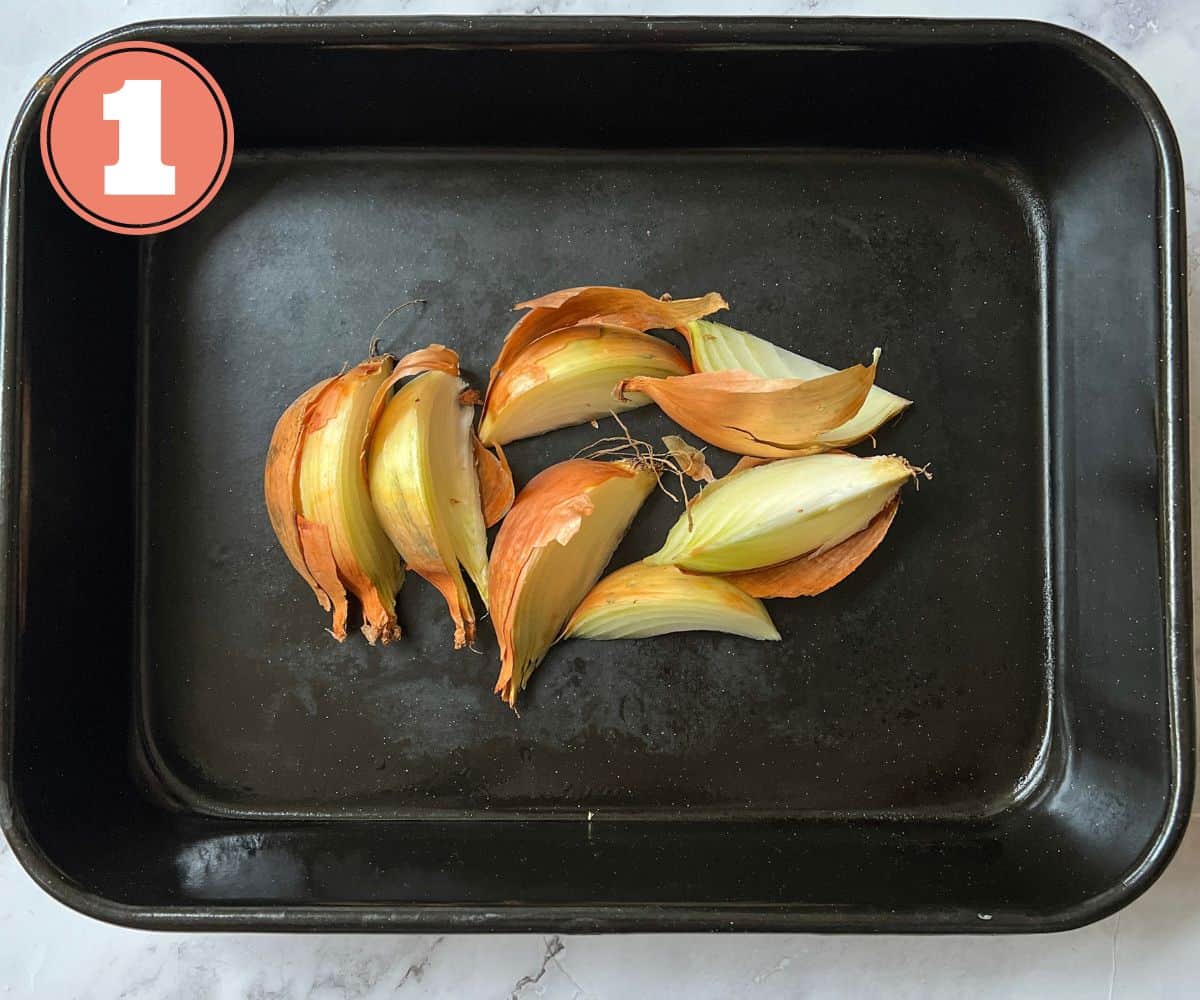 Wedges of onion in a roasting tin.