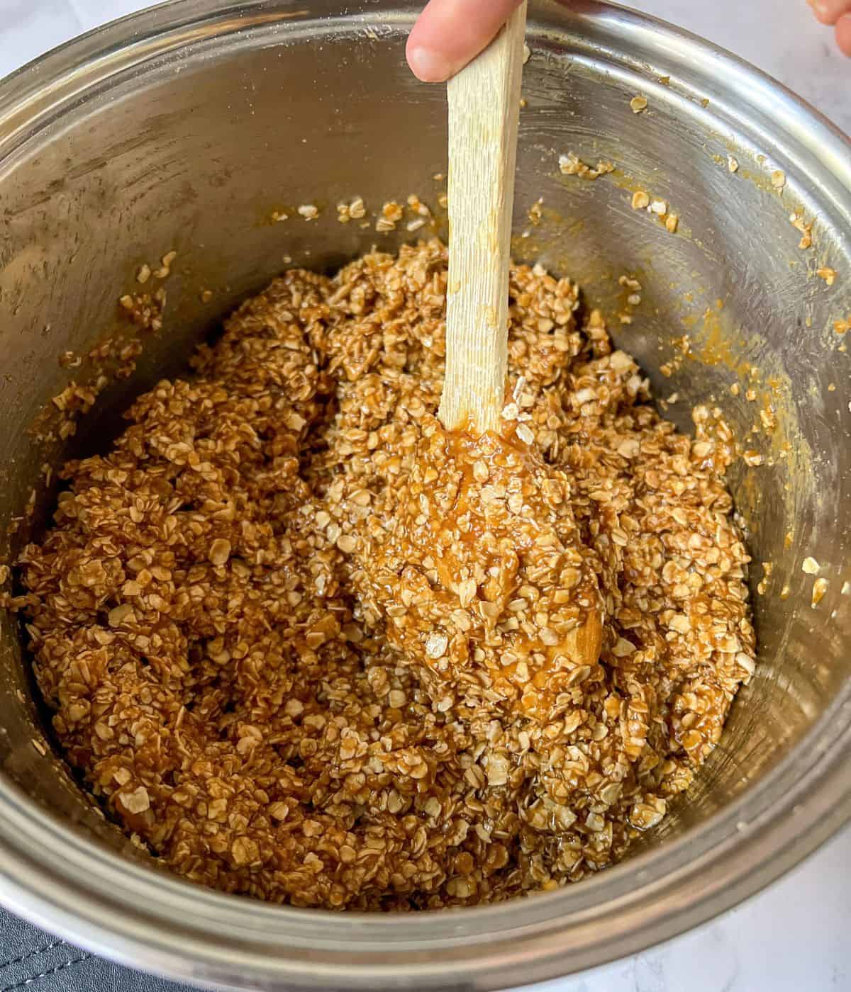 Flapjack mixture being stirred in a saucepan.