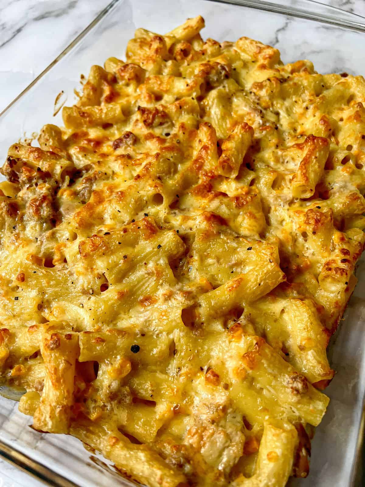 Pasta bake topped with cheese in a rectangle baking dish.