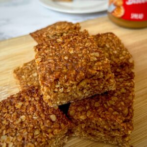 A stack of flapjacks on a wooden chopping board.