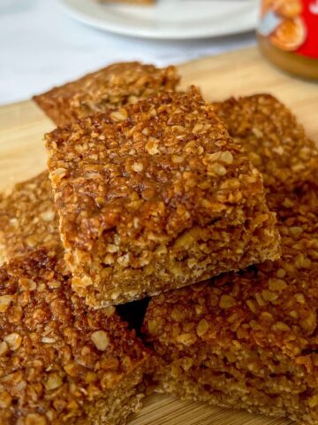 A stack of flapjacks on a wooden chopping board.