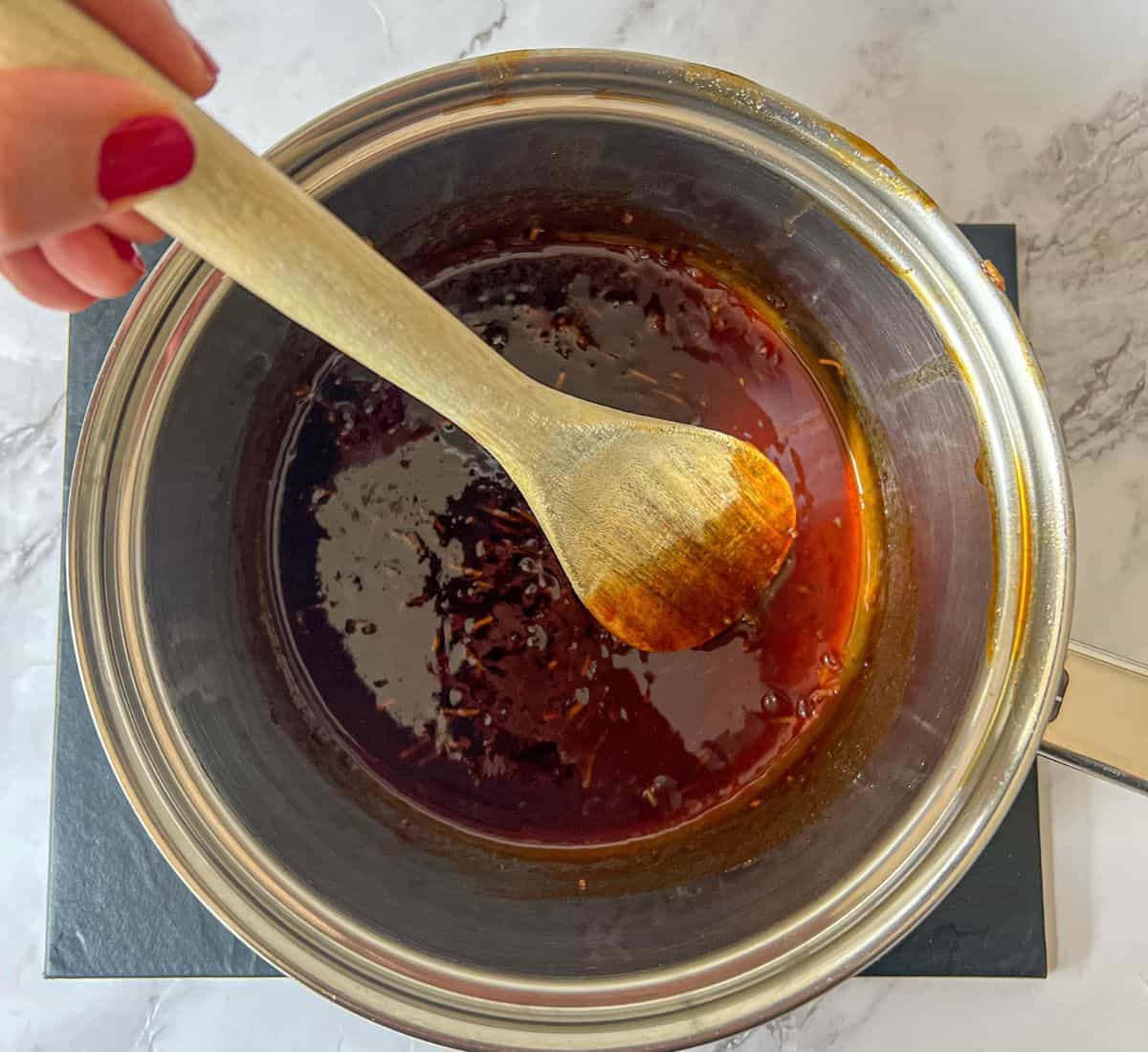 Gochujang sauce being stirred in a saucepan.