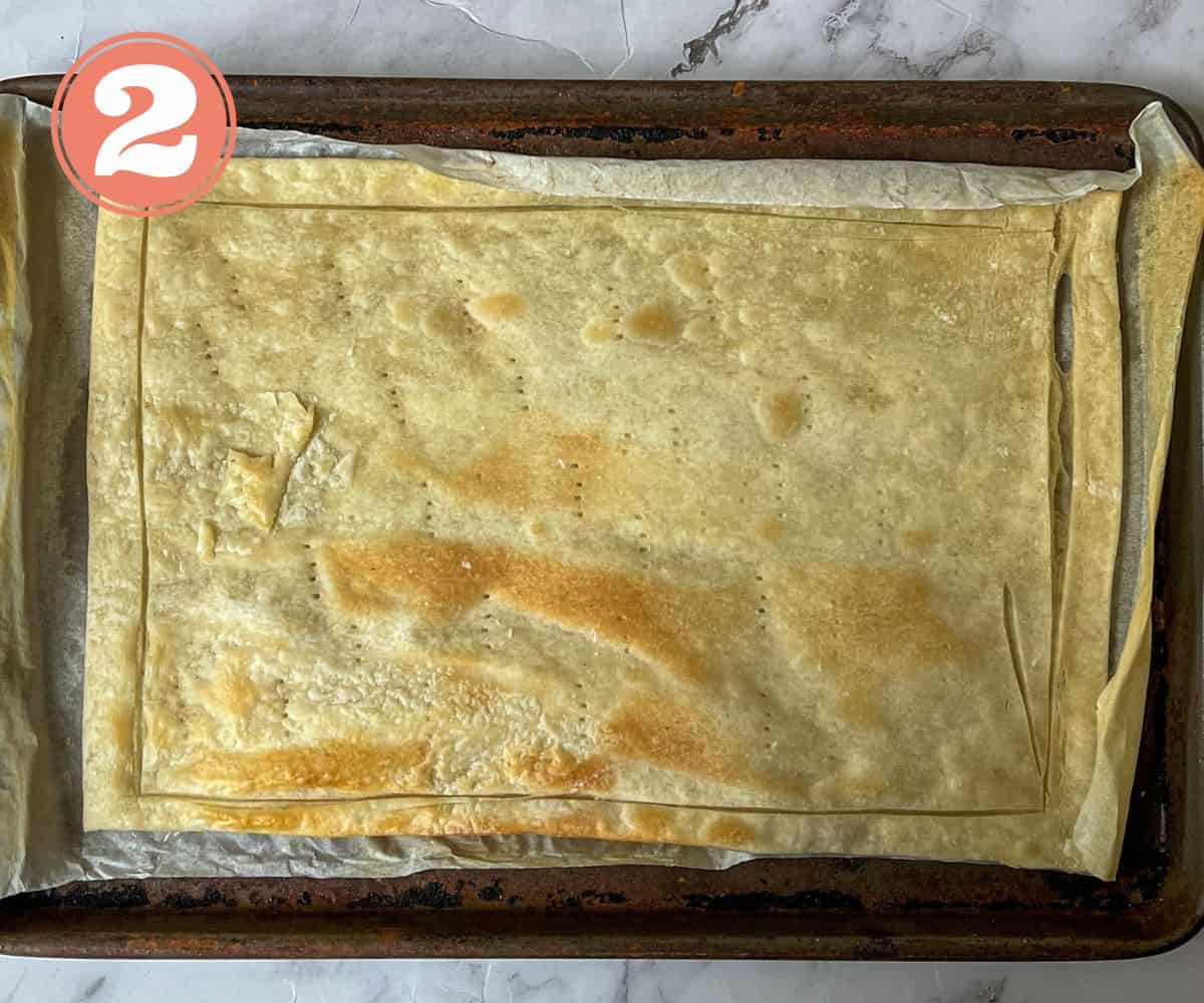 A cooked rectangle of puff pastry on a baking tray.