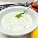 Mint and yoghurt dip in a white bowl.