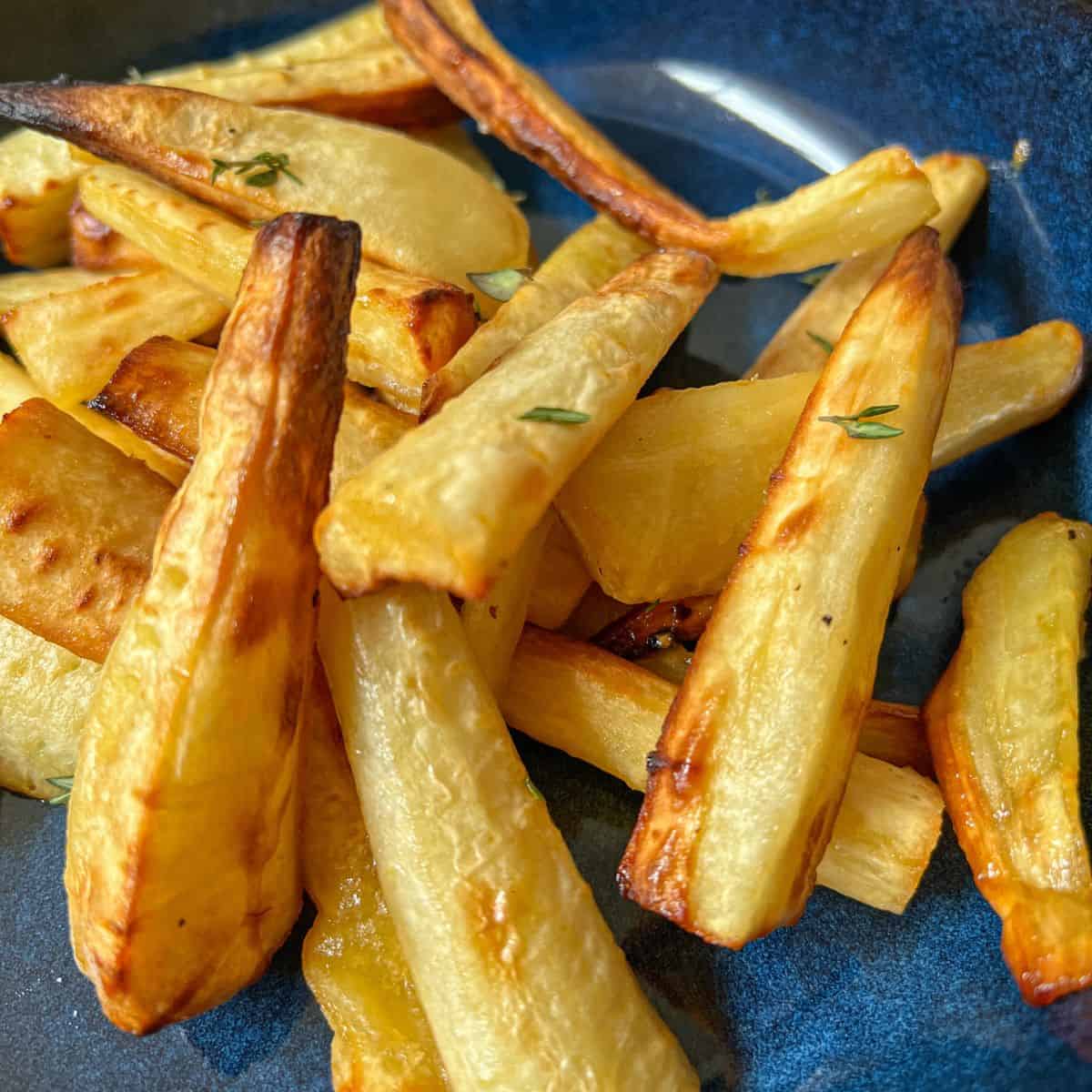 Roasted parsnips in a blue bowl.
