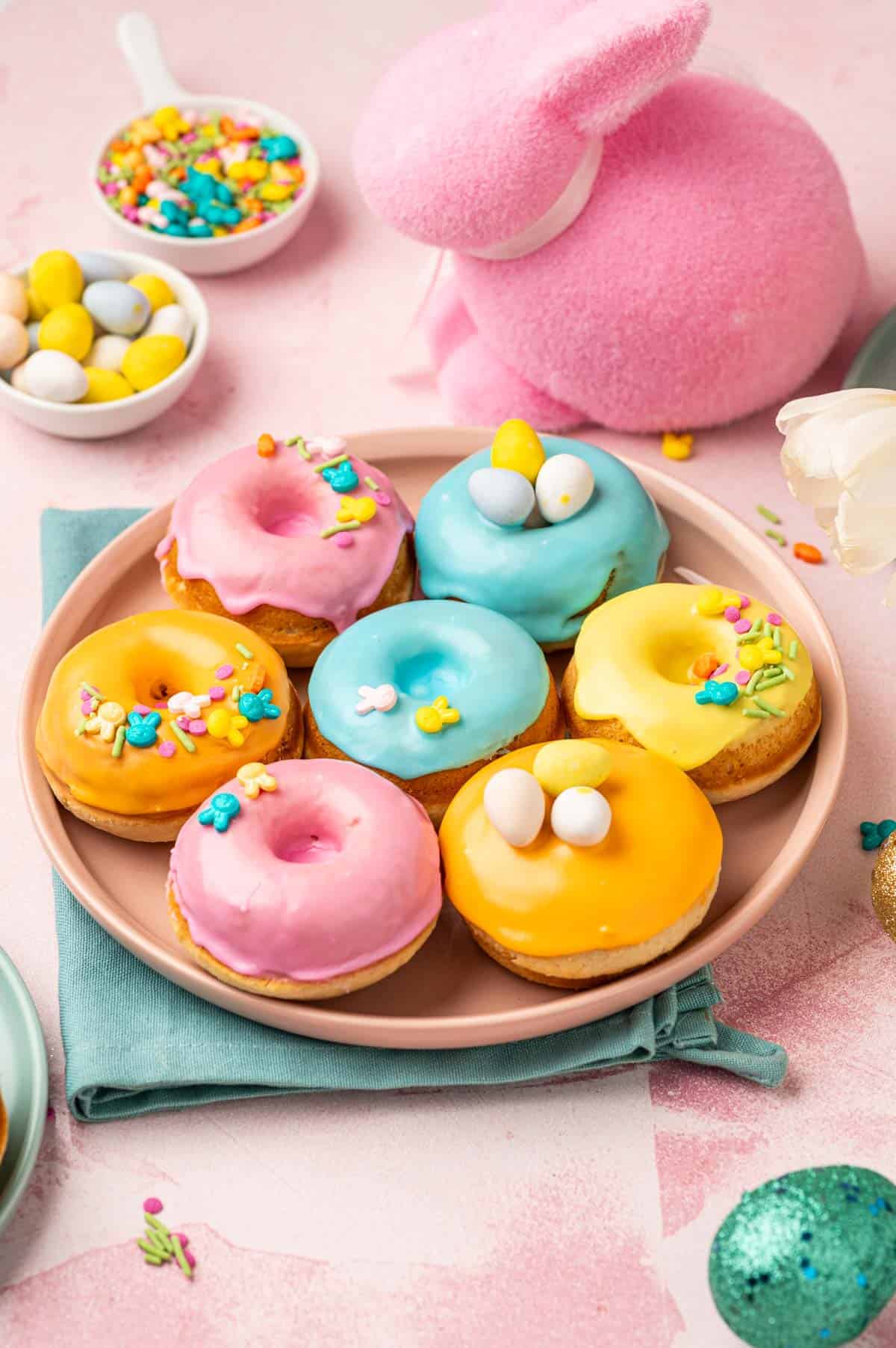 Pastel coloured mini donuts on a plate.