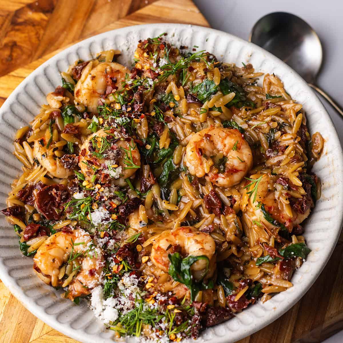 Shrimp orzo in a white bowl.